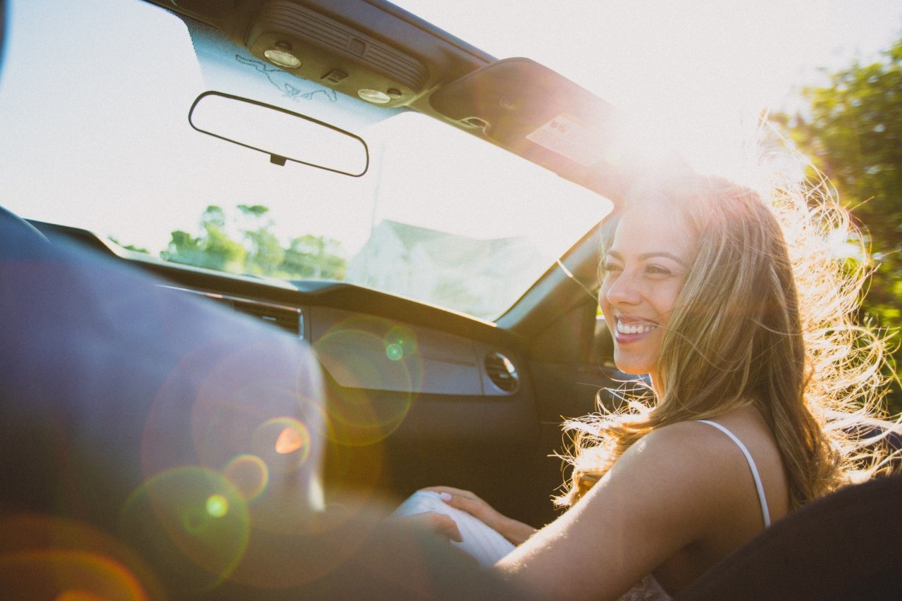 Woman smiling in convertible Ford Mustang in Arizona.